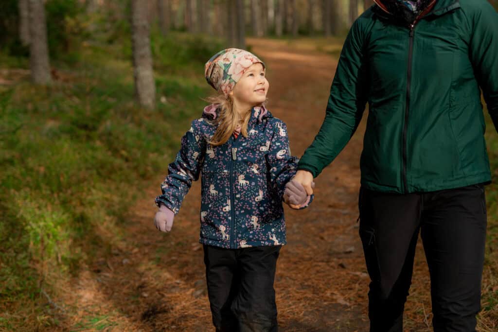 Lapsi ja aikuinen kävelevät käsi kädessä